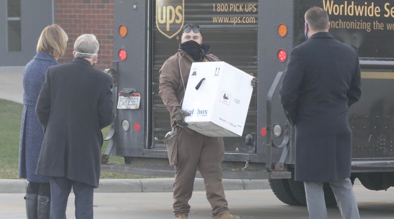 Gov. Mike DeWine and his wife Fran along with Springfield Regional Medical Center President Adam Groshans, right, watch as the first doses of the COVID-19 vaccine arrive at Tuesday morning, Dec. 15, 2020. BILL LACKEY/STAFF