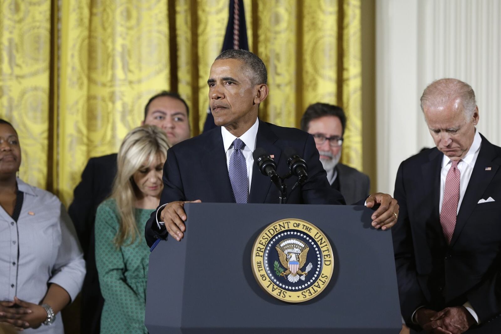 President Barack Obama, joined by Vice President Joe Biden and gun violence victims, speaks in the East Room of the White House in Washington, Tuesday, Jan. 5, 2016, about steps his administration is taking to reduce gun violence. Also on stage are stakeholders, and individuals whose lives have been impacted by the gun violence. (AP Photo/Carolyn Kaster)