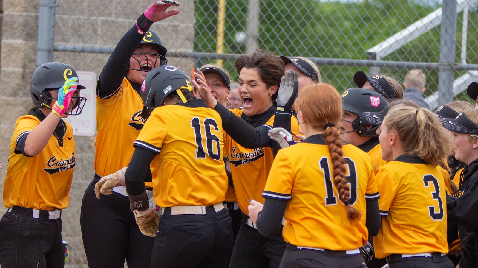 Natalie Carr (16) is mobbed at home plate after leading off the bottom of the first inning with a home run during the Elks' 8-1 victory over Lakota West in a Division I district final Thursday at Kings High School. JEFF GILBERT / CONTRIBUTED