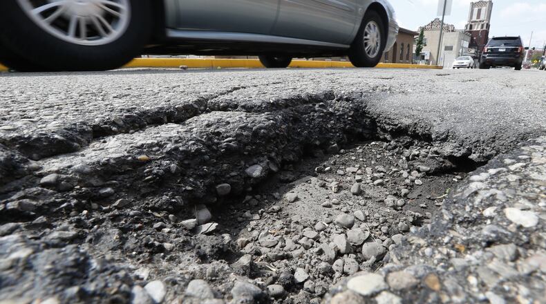 Cars drive around a pothole, several inches deep, along Center Street between Pleasant Street and North Street Friday. Bill Lackey/Staff