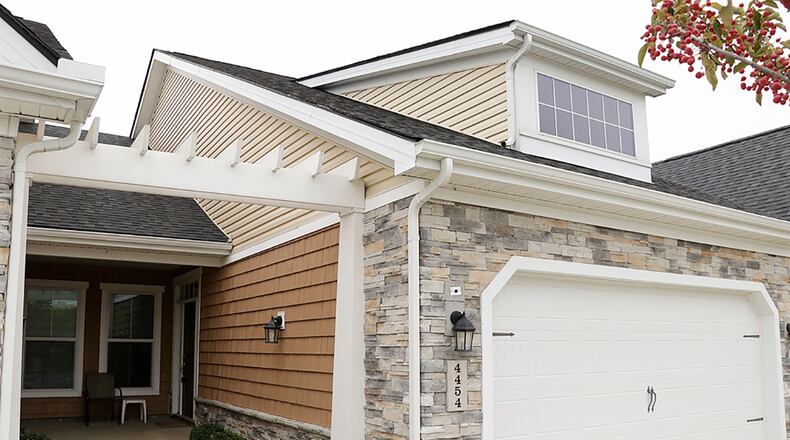 The stone-and-frame home has about 1,040 sq. ft. of living space. One of a 5-unit building in the Cottages of Beavercreek, the condominium has an attached, 2-car garage with extra off-street parking. CONTRIBUTED PHOTO BY KATHY TYLER