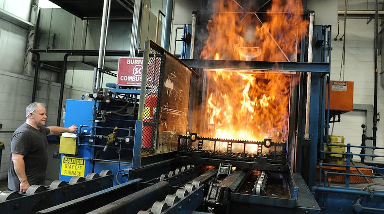 Wes Fugate, an employee of Winston Heat Treating, removes heat treated parts out of a furnace. MARSHALL GORBY\STAFF