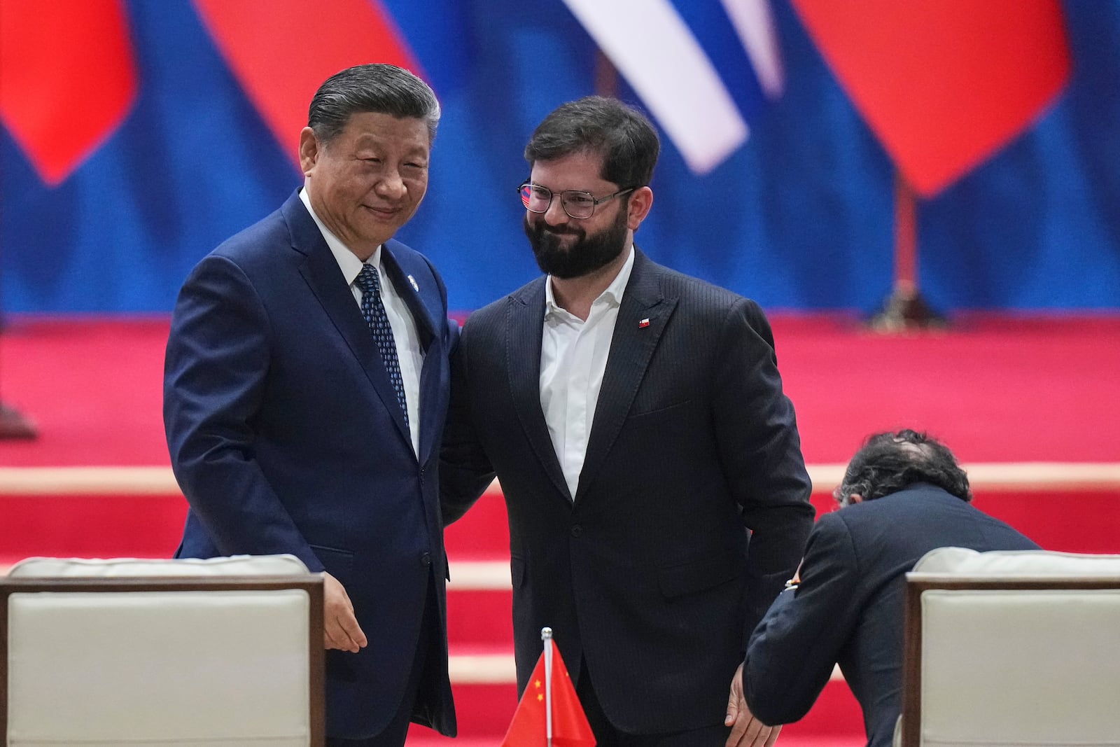 Chinese President Xi Jinping, left, is greeted by Chilean President Gabriel Boric, center, after delivering his opening speech for the Fourth Ministerial Meeting of the Forum of China and Community of Latin American and Caribbean States in Beijing, Tuesday, May 13, 2025. (AP Photo/Andy Wong)