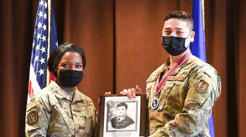 Chief Master Sgt. Sharma Haynes, 88th Comptroller Squadron, presents Senior Airman Mateo Espinoza, U.S. Air Force School of Aerospace Medicine, with the John L. Levitow Award during the Airman Leadership School graduation ceremony Dec. 2 at Wright-Patterson Air Force Base. The Levitow Award goes to the top graduate. U.S. AIR FORCE PHOTO/JAIMA FOGG