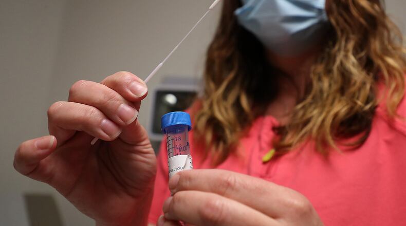 Lisa Saunders, Director of Quality and a RN at the Rocking Horse Center, shows an example of one of the Covid-19 tests. BILL LACKEY/STAFF