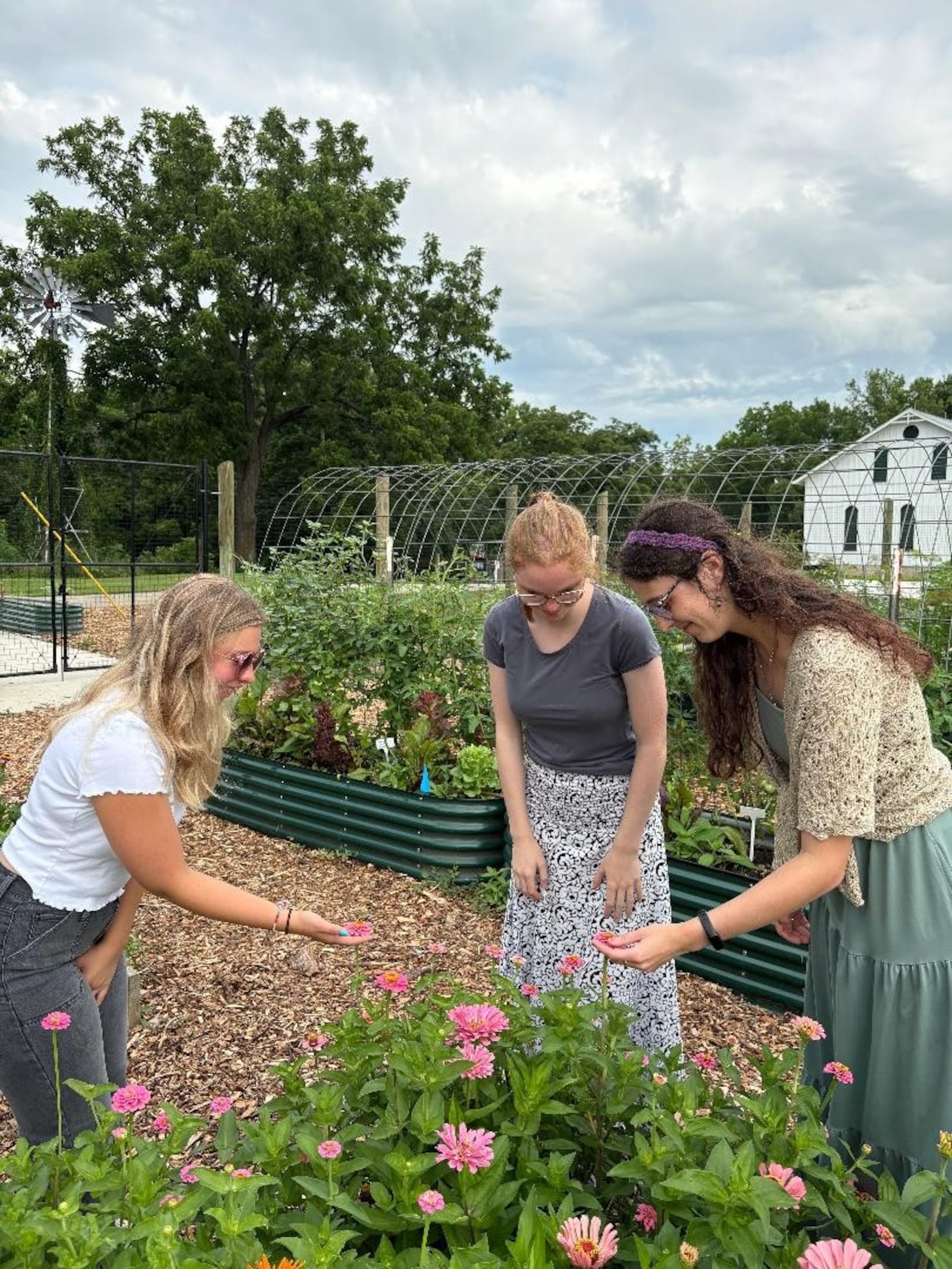 Left to right: University of Dayton students Grace Haas, Hannah Scheuller and Shannon Dennemann examine flowers within the demonstration garden at Possum Creek MetroPark. Photo by Russell Florence Jr.