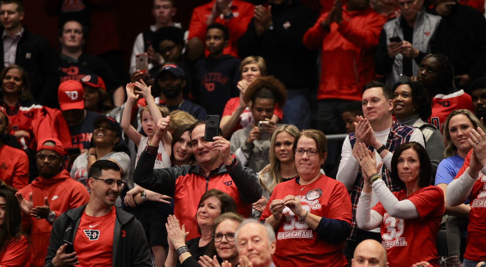 Dayton fans, including Ryan Mikesell's parents Reed and Lisa, center, cheer during the final minutes of a victory over George Washington on March 7, 2020, at UD Arena. David Jablonski/Staff