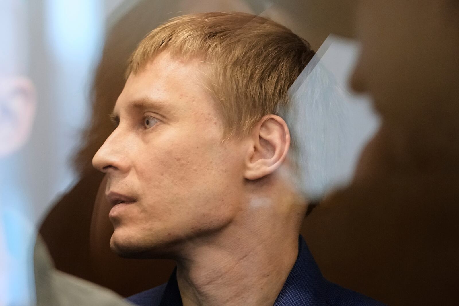 Russian journalist Konstantin Gabov, accused of working for a group founded by the late Russian opposition politician Alexei Navalny, stands in a defendant's cage of the Nagatinsky District Court in Moscow, Russia, on Tuesday, April 15, 2025. (AP Photo)