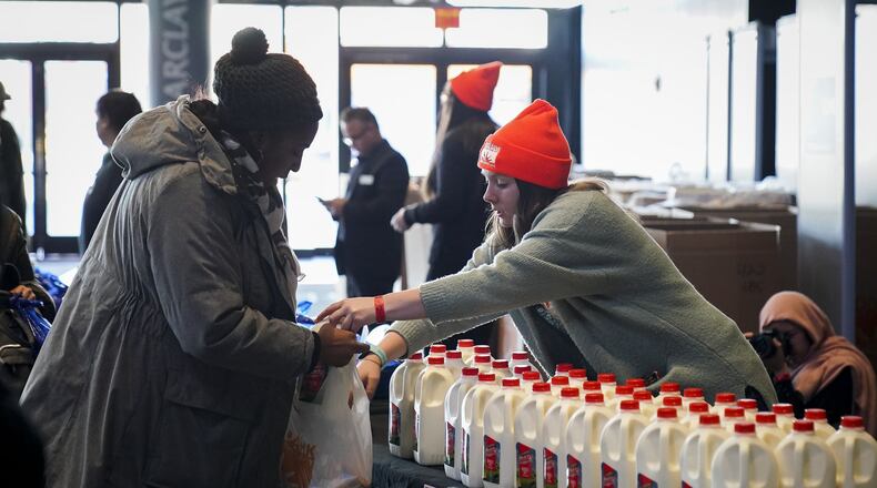 A woman receives a carton of milk at a food distribution center for federal workers impacted by the government shutdown, at the Barclays Center on Jan. 22, 2019, in the Brooklyn borough of New York City. Organized by Food Bank For New York City and the Barclays Center, the pop-up distribution center was organized to provide food, vital products, and other resources for furloughed federal workers. (Photo by Drew Angerer/Getty Images)