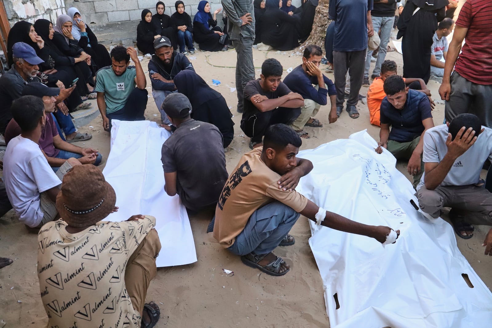 Relatives of Palestinians killed at an aid distribution center run by the Gaza Humanitarian Foundation, a U.S.-backed organization approved by Israel, mourn over their bodies during their funeral at Nasser Hospital in Khan Younis, southern Gaza Strip, Saturday, July 19, 2025. (AP Photo/Mariam Dagga)