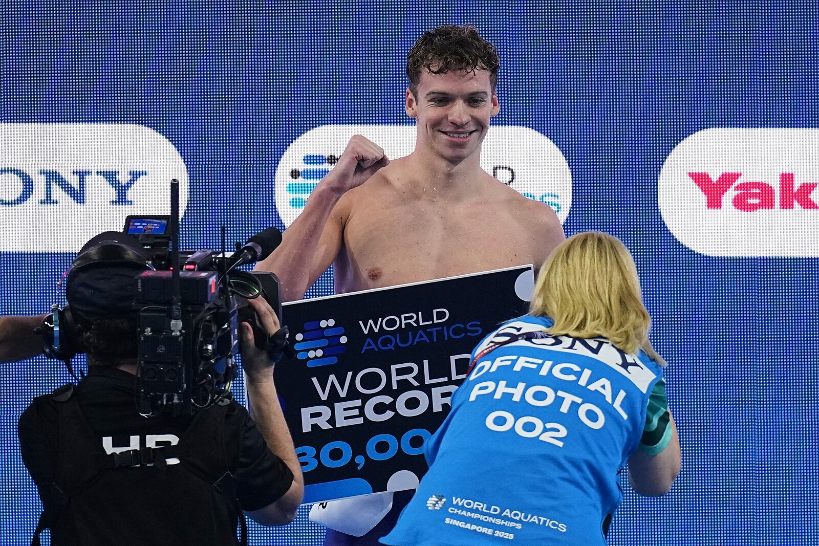 Leon Marchand of France celebrates after receiving an award for creating a new world record following the men's 200-meter individual medley semifinals at the World Aquatics Championships in Singapore, Wednesday, July 30, 2025. (AP Photo/Ng Han Guan)