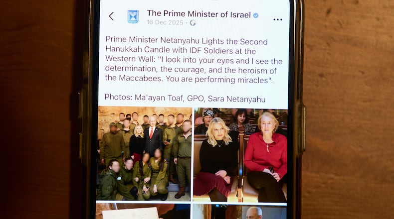 A Facebook post of the Prime Minister of Israel with a retouched photo of the Prime Minister’s wife, Sara Netanyahu, is displayed on a phone in Ramat Gan, Israel, Jan, 9, 2026 (AP Photo/Oded Balilty)