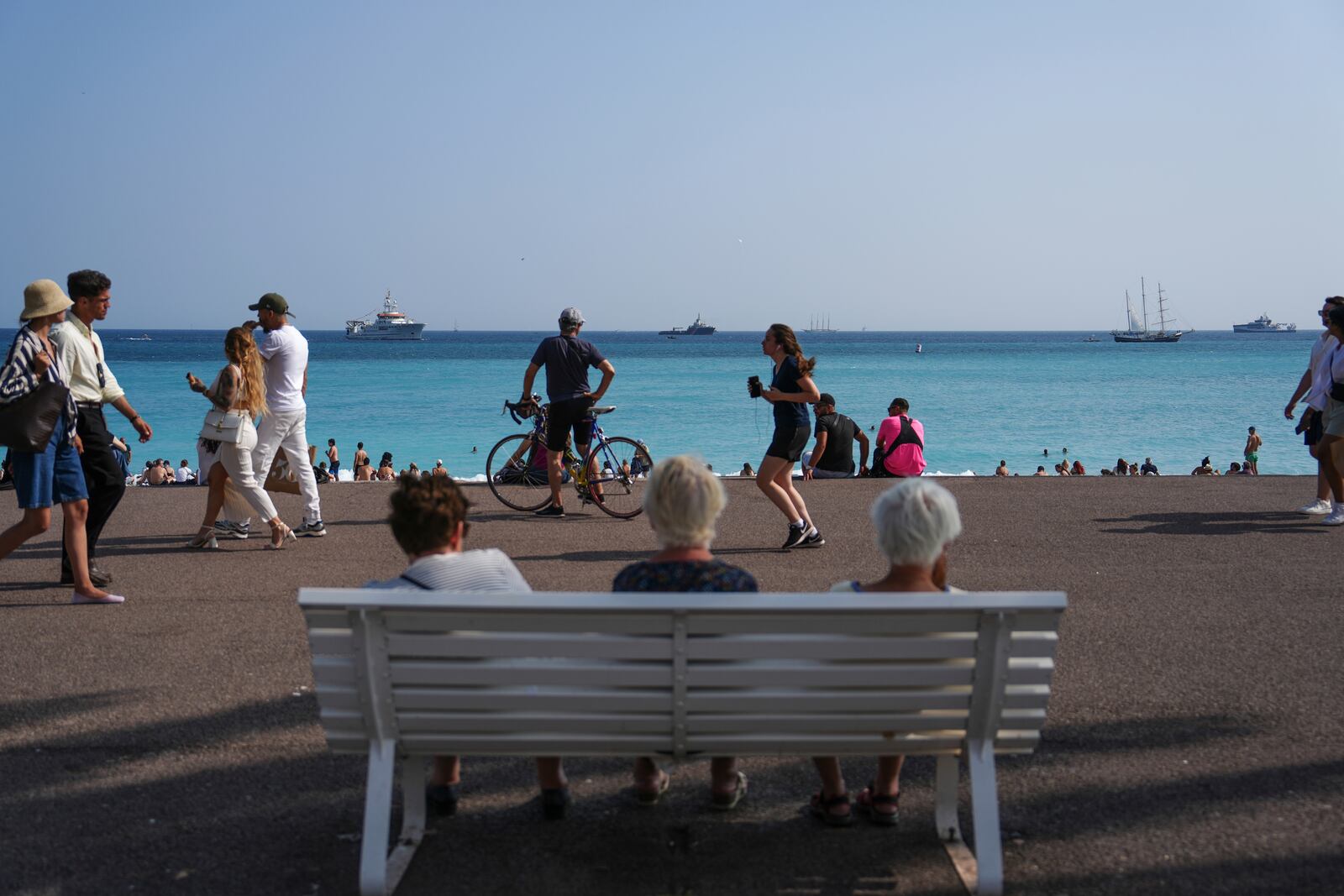 People enjoy the beach as vessels sail during the "Ocean Wonders" event in honor of World Oceans Day ahead of the U.N. Ocean Conference on Sunday, June 8, 2025, in Nice, France. (AP Photo/Annika Hammerschlag)