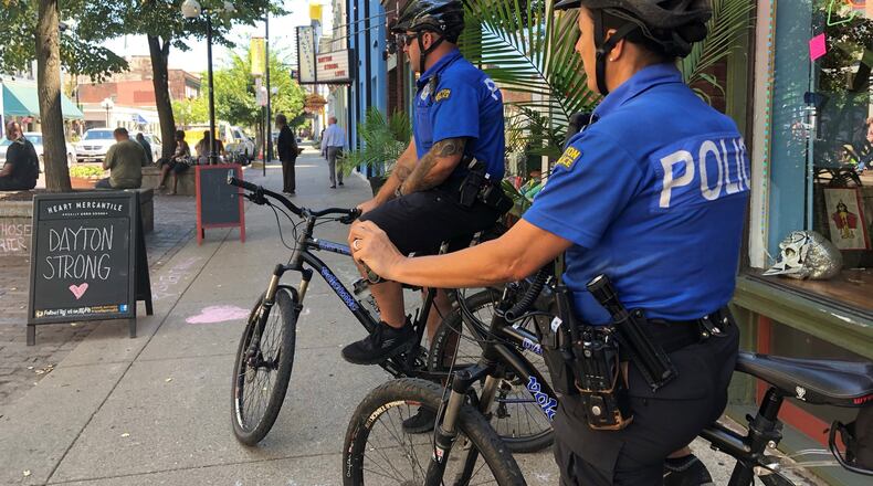Dayton police officers Kim Pittl (forefront) and Jamie Moebius said they normally patrol the Oregon District and the surrounding areas. This week they said there have been extra officers in the area and they have mainly been patrolling East Fifth Street. BONNIE MEIBERS/STAFF