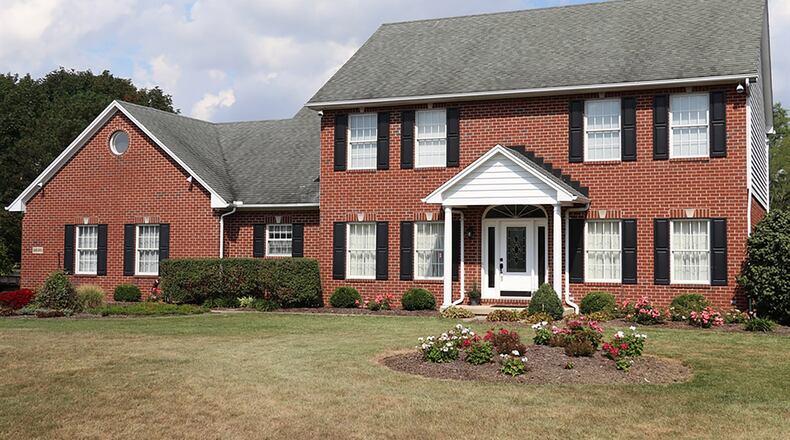 Rounded islands planted with grasses and flowering plants embellish the deep frontage that precedes the entrance to this 2-story, brick home in Clayton’s Springlake Country Estates. The peaceful view from the front door takes in the large common area across the street, where green space, mature trees and a community pond can all be enjoyed from a nearby gazebo. CONTRIBUTED PHOTOS BY KATHY TYLER