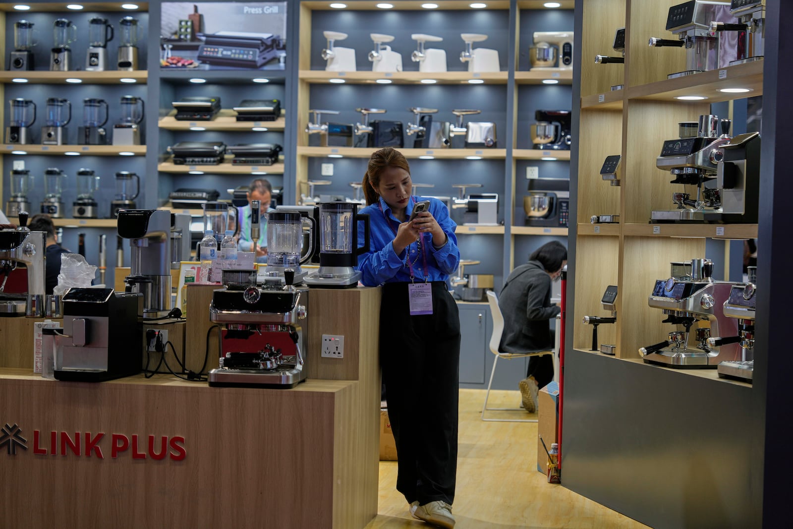 FILE - A vendor of coffee machines waits for customers at the 137th Canton Fair in Guangzhou, in southern China's Guangdong province on April 16, 2025. (AP Photo/Ng Han Guan, File)