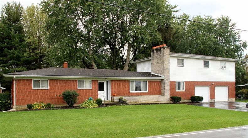 The facade of this original brick ranch in Spring Valley Twp. is edged with a raised flower box in cut stone. Bushes and giant hosta are planted in the front flowerbeds. The view across the street encompasses a small orchard, a cluster of tall pine trees and a pasture all surrounded with rustic split-rail horse fencing. CONTRIBUTED PHOTOS BY KATHY TYLER
