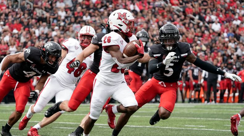 Miami (Ohio) running back Kevin Davis (26) runs during the first half of an NCAA college football game against Cincinnati, Saturday, Sept. 4, 2021, in Cincinnati. Davis scored two touchdowns in Saturday's win over Long Island. (AP Photo/Jeff Dean)