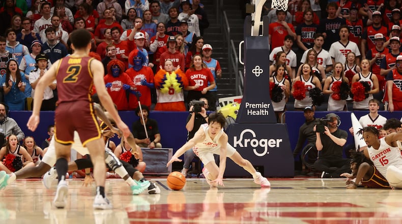 Dayton's Mike Sharavjamts dives for a loose ball against Loyola on Tuesday, Jan. 31, 2023, at UD Arena. David Jablonski/Staff