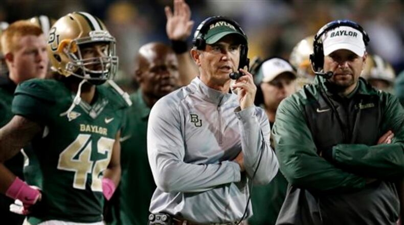 FILE - In this Oct. 19, 2013, file photo, Baylor head coach Art Briles, center, watches during the second half of an NCAA college football game against Iowa State in Waco, Texas. Baylor University's board of regents says it will fire Briles and re-assign university President Kenneth Starr in response to questions about its handling of sexual assault complaints against players. The university said in a statement Thursday, May 26, 2016, that it had suspended Briles "with intent to terminate." Starr will leave the position of president on May 31, but the school says he will serve as chancellor. (AP Photo/Tony Gutierrez, File)