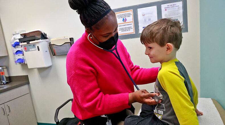 Toyin Adeyanju, a pediatric nurse practitioner, examines Eli Rue, 5, in the pediatric clinic at the Rocking Horse Center Tuesday, Jan. 24, 2023. BILL LACKEY/STAFF