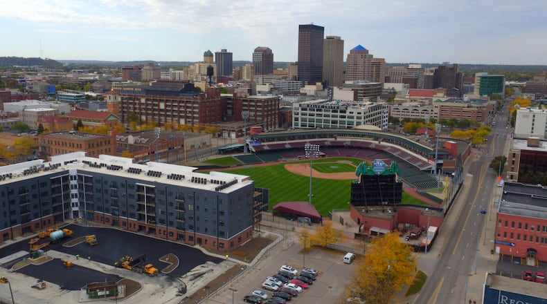A view of the Water Street District and downtown Dayton. The Centerfield Flats, the blue and red apartment building, is expected to open next month. The Delco Lofts, on the other side of Fifth Third Field, opened in 2017, offering 133 units. Developer Crawford Hoying, in partnership with Woodard Development, plans to redevelop the massive Mendelsons liquidation outlet building just south of the ballpark and Delco apartments. JAROD THRUSH / STAFF