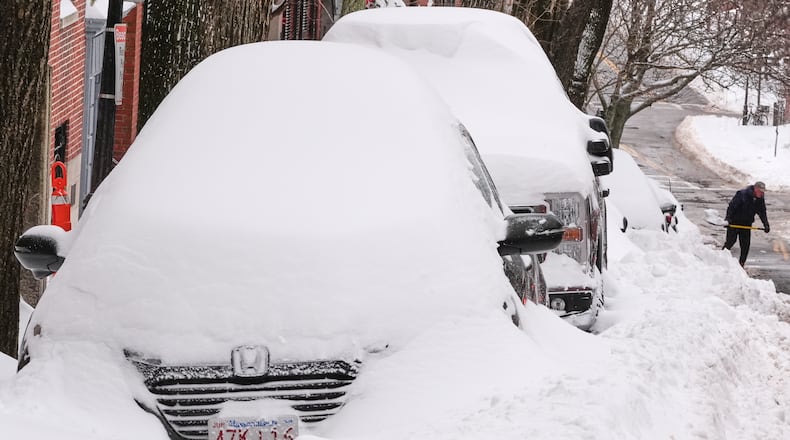 A man digs a car out of the snow on Beacon Hill following a winter storm that dumped more than a foot of snow across the region, Monday, Jan. 26, 2026, in Boston. (AP Photo/Charles Krupa)