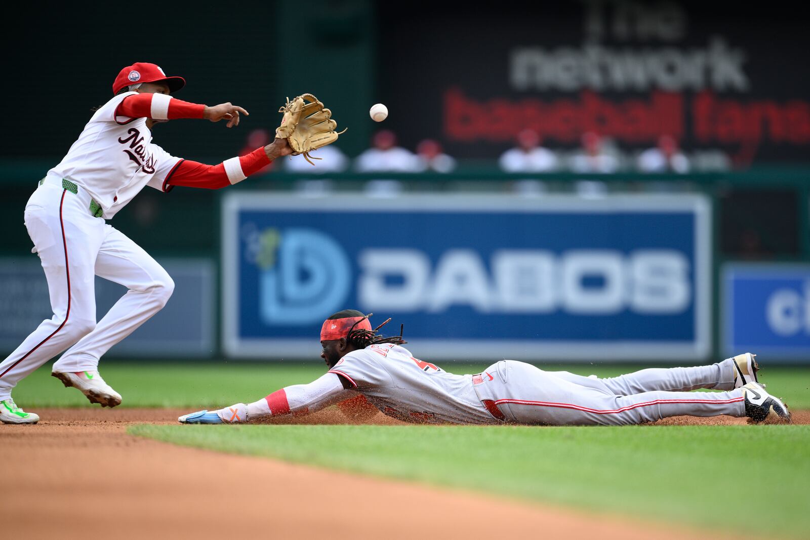 Cincinnati Reds' Elly De La Cruz, right, steals second base as Washington Nationals shortstop CJ Abrams, left, fields the late throw during the fourth inning of a baseball game, Wednesday, July 23, 2025, in Washington. (AP Photo/Nick Wass)
