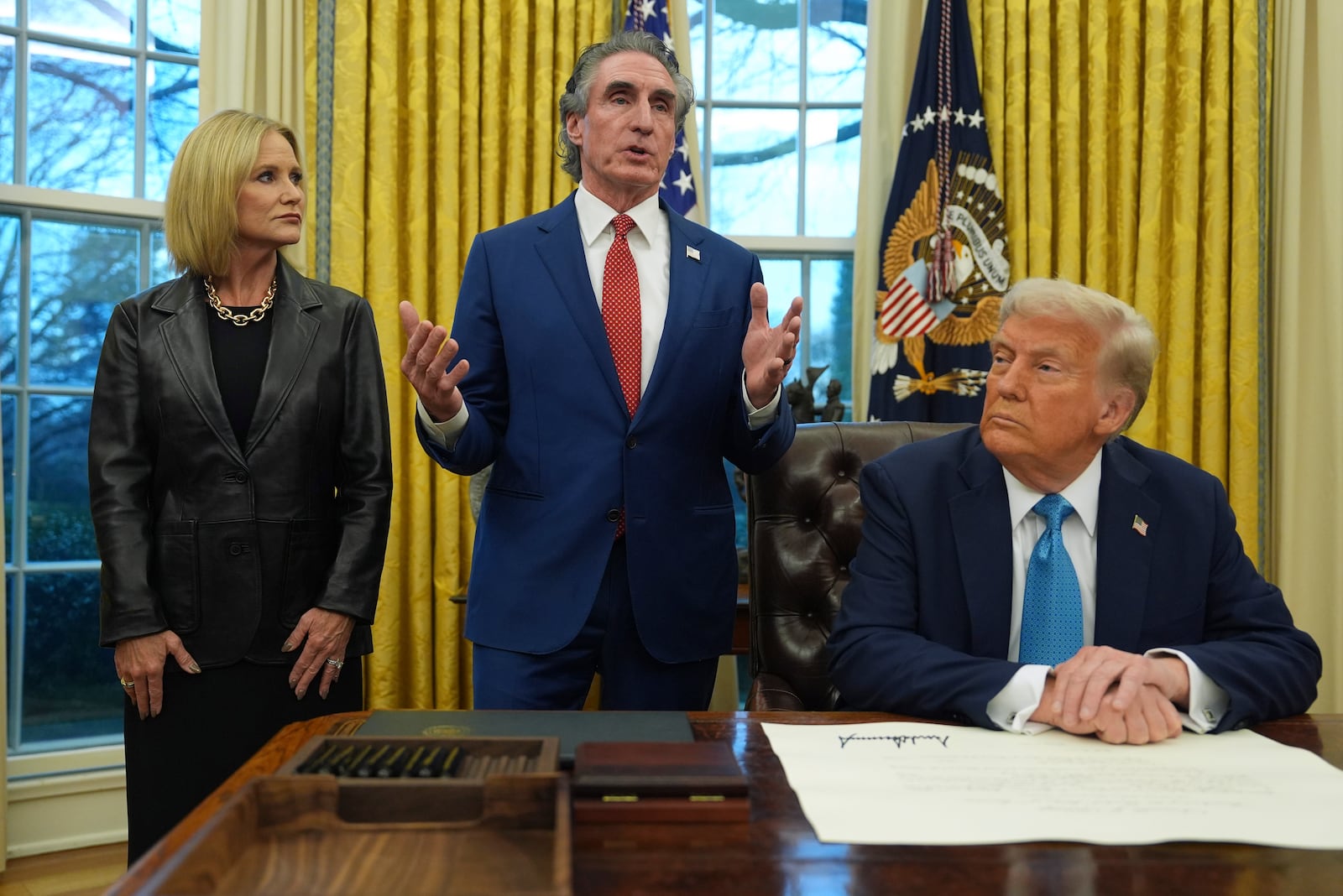 FILE - Interior Secretary Doug Burgum speaks as his wife, Kathryn, and President Donald Trump listen, in the Oval Office of the White House, Friday, Jan. 31, 2025, in Washington. (AP Photo/Evan Vucci,File)