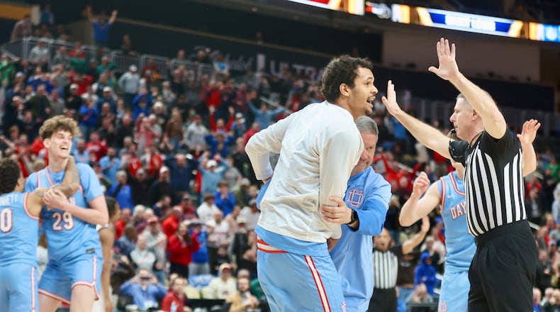 Dayton trainer Mike Mulcahey pulls De'Shayne Montgomery off the court after he left the bench to celebrate the go-ahead basket by Amaël L'Etang in the final second against Saint Louis in the semifinals of the Atlantic 10 Conference tournament on Saturday, March 14, 2026, at PPG Paints Arena in Pittsburgh. David Jablonski/Staff