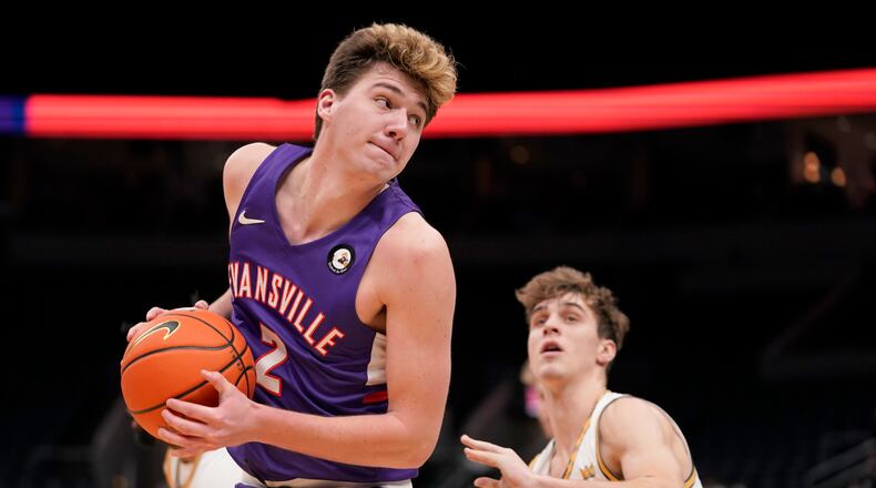 Evansville's Blake Sisley, left, looks to the basket as Valparaiso's Preston Ruedinger defends during the second half of an NCAA college basketball game in the first round of the Missouri Valley Conference tournament Thursday, March 3, 2022, in St. Louis. (AP Photo/Jeff Roberson)