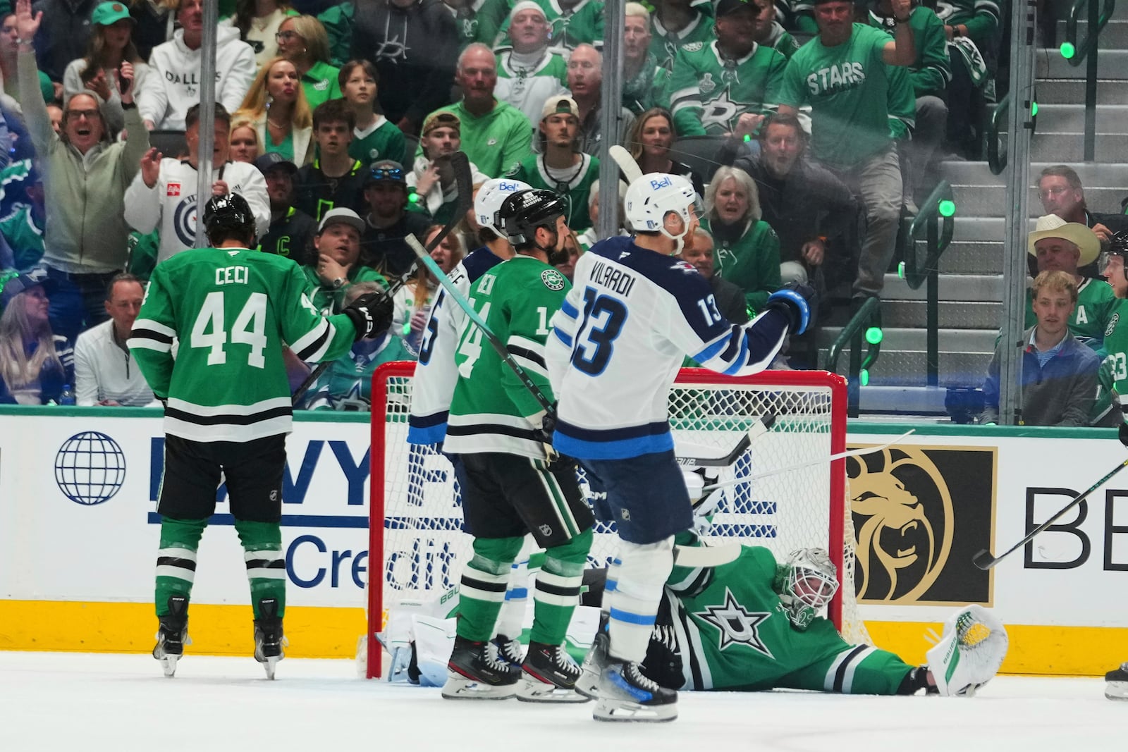 Winnipeg Jets' Gabriel Vilardi (13) celebrates a goal scored by Kyle Connor, standing nearby, as Dallas Stars goaltender Jake Oettinger (29) lies on the ice after the score in the first period of Game 3 of a second-round NHL hockey playoff series in Dallas, Sunday, May 11, 2025. (AP Photo/Julio Cortez)