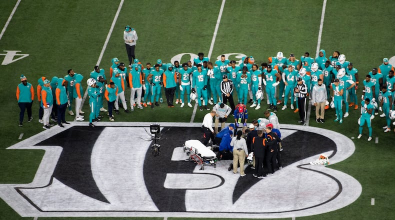 Teammates gather around Miami Dolphins quarterback Tua Tagovailoa (1) after an injury during the first half of an NFL football game against the Cincinnati Bengals, Thursday, Sept. 29, 2022, in Cincinnati. (AP Photo/Emilee Chinn)