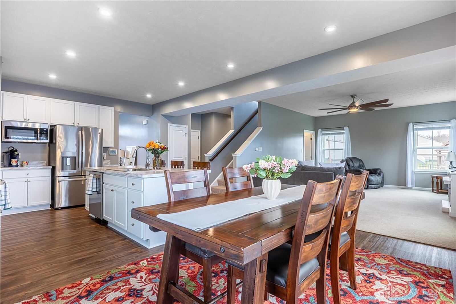 The open concept kitchen, dining and great room areas have recessed lighting. The great room has a ceiling fan and the kitchen and dining areas have LVT flooring.