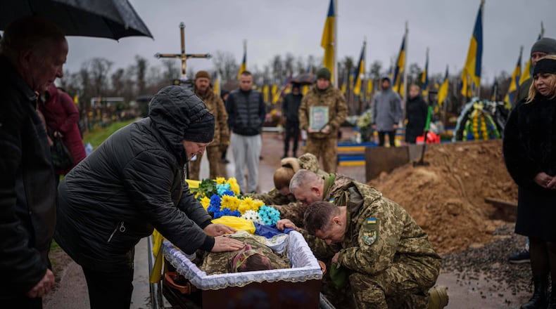 Natalia cries at the coffin of her son Ruslan Zhygunov, a Ukrainian serviceman, who was killed at the frontline near Rusyn Yar village, during his funeral ceremony in Hostomel, Ukraine, on Saturday, Nov. 22, 2025. (AP Photo/Evgeniy Maloletka)