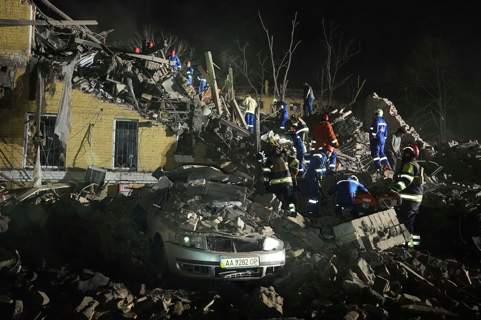 Ukrainian searchers clear the rubble after a Russian ballistic missile attack in Kyiv, Ukraine, early Thursday, April 24, 2025. (AP Photo/Efrem Lukatsky)