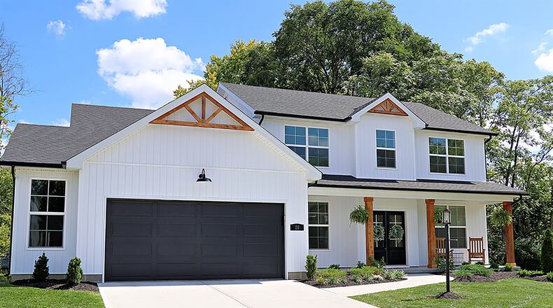 The 3-bedroom 2-story home has about 2,300 sq. ft. of living space. The property includes an oversized, 2-car garage and a private back yard with in-ground swimming pool. King-post wooden trusses accent the roof peaks and complement the rustic wood support columns of the covered front porch. CONTRIBUTED PHOTO BY KATHY TYLER