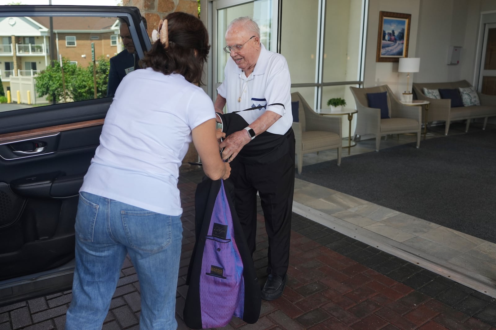The Rev. James Kelly takes off his Roman collar and gets ready to go to a doctor’s appointment in Blue Bell, Pa., on Wednesday, June 18, 2025. (AP Photo/Luis Andres Henao)