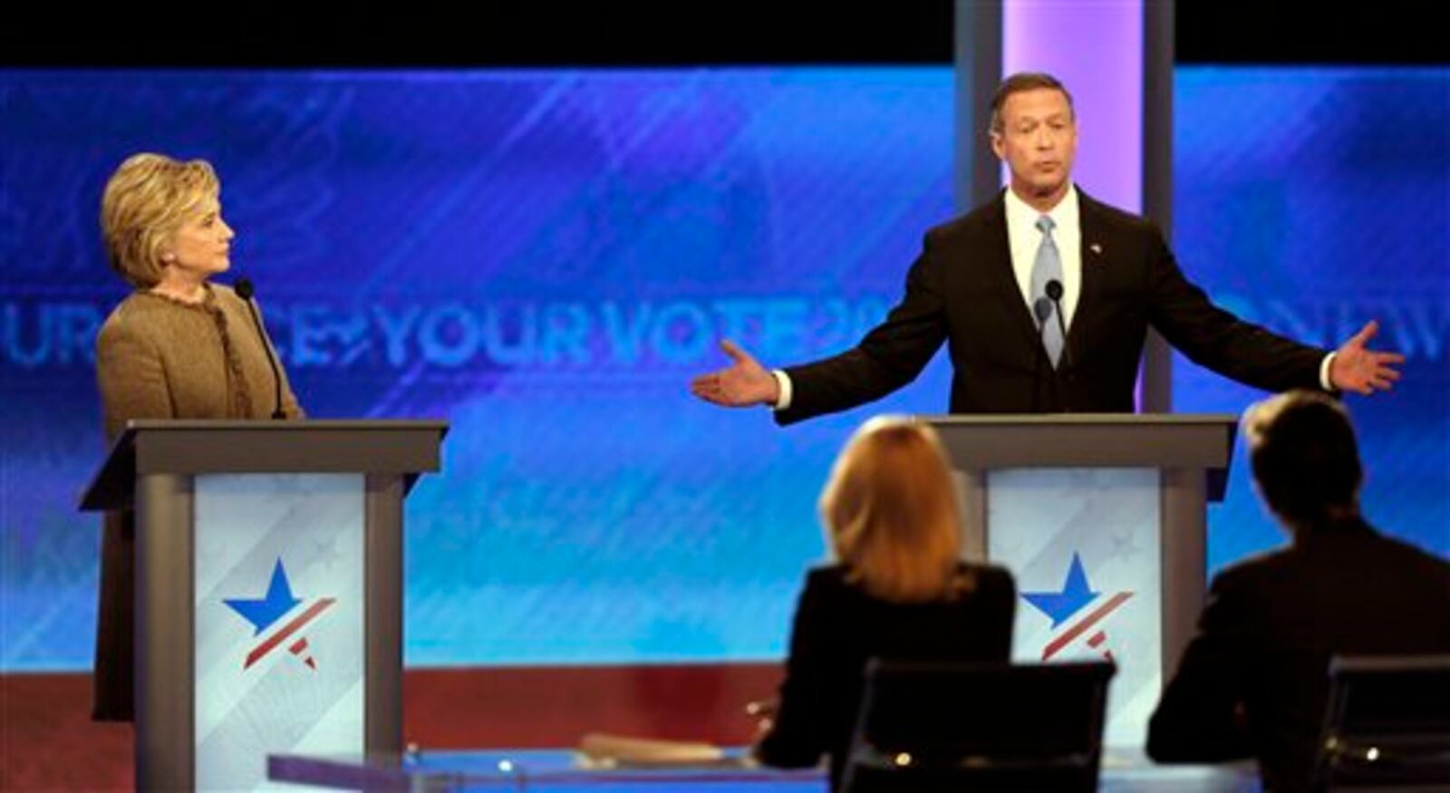 Hillary Clinton, left, listens as Martin OMalley speaks during a Democratic presidential primary debate Saturday, Dec. 19, 2015, at Saint Anselm College in Manchester, N.H. (AP Photo/Jim Cole)