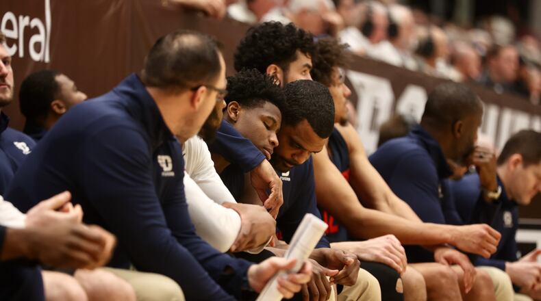 Dayton's Ricardo Greer comforts Malachi Smith after he suffered an injury in the second half against St. Bonaventure on Saturday, Feb. 4, 2023, at the Reilly Center in St. Bonaventure, N.Y. David Jablonski/Staff