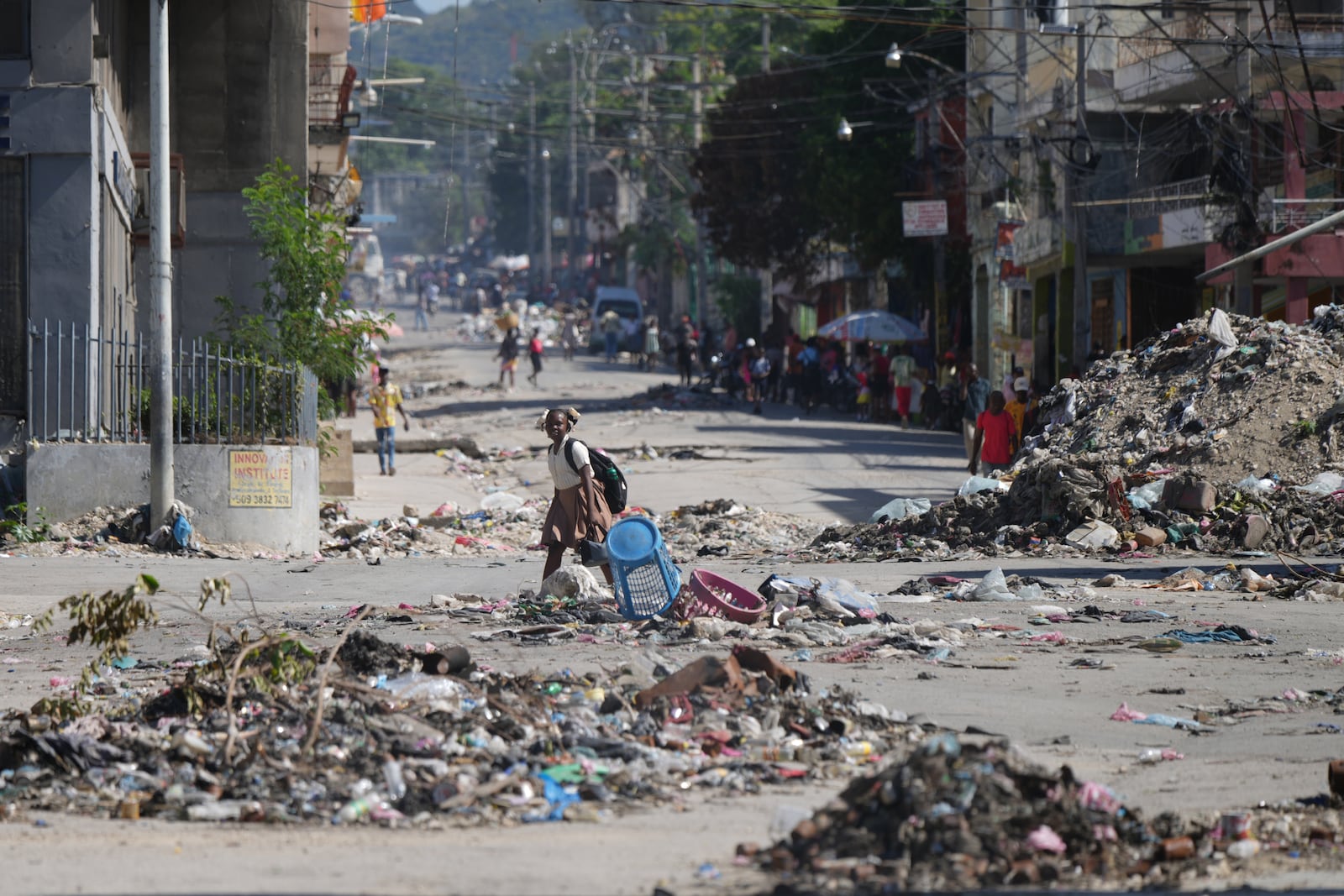 A youth crosses a street littered with garbage in downtown in Port-au-Prince, Haiti, Tuesday, Jan. 20, 2026. (AP Photo/Odelyn Joseph)