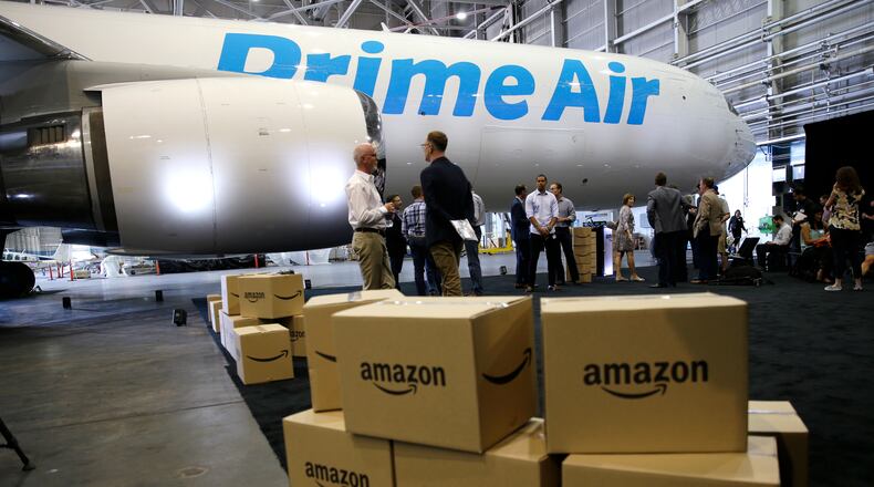 FILE - In this Thursday, Aug. 4, 2016, file photo, Amazon.com boxes are shown stacked near a Boeing 767 Amazon “Prime Air” cargo plane on display in a Boeing hangar in Seattle. Amazons announcement on Monday, Jan. 30, 2017, of a new air cargo hub in Kentucky is the latest way the e-commerce retailer is dipping its toe, or perhaps whole foot, into building out its shipping and logistics unit. If successful, the move ultimately means lower costs for Amazon but it could eventually pit Amazon against package deliverers like FedEx and UPS. (AP Photo/Ted S. Warren, File)