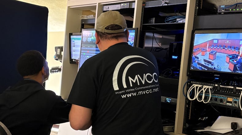 Miami Valley Communications Council technicians Evan Russell, left, and Mike Sopronyi prepare equipment for the Tuesday evening, May 27, 2025, Kettering City Council meeting. Council members on Tuesday unanimously approved a merger between MVCC and Miami Valley Educational Computer Association to form a new organization, the Miami Valley Technology and Communication Group. JEN BALDUF/STAFF
