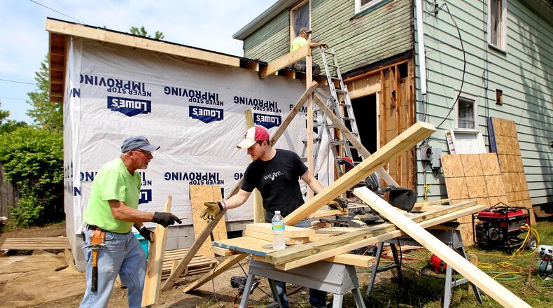 From left, Clark Helvey, Pastor of Outreach and Missions at Berachah Baptist Church in Middletown, Caleb Wood and Wayne Gallagher work to frame an addition to the back of a Middletown home Thursday, May 9, 2013.The baptist church is taking a home that was set to be demolished by the city and doing an extreme makeover for a single mother and her two children. NICK DAGGY / STAFF