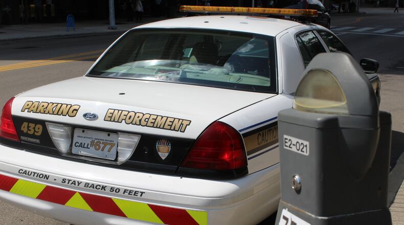 Some downtown visitors, residents and business owners have complained about aggressive parking enforcement officers. The city of Dayton is evaluating its parking situation. CORNELIUS FROLIK / STAFF
