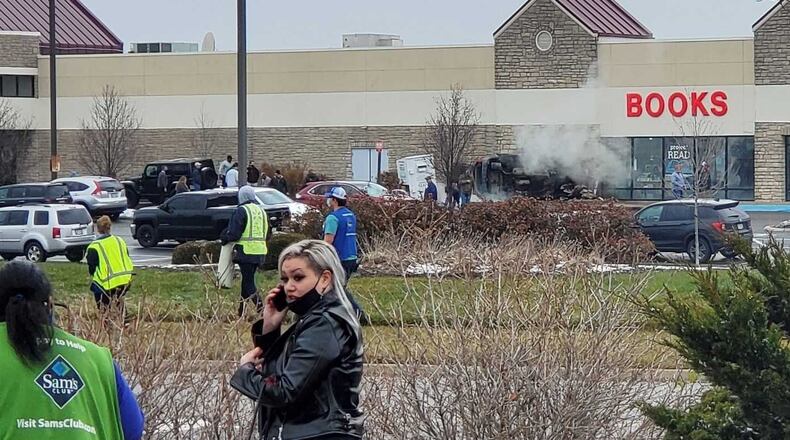 A vehicle went across a road and parking lot and into the Books store in the Washington Park shopping center. The vehicle landed on its side and briefly was on fire. DARIUS BABCOCK/STAFF