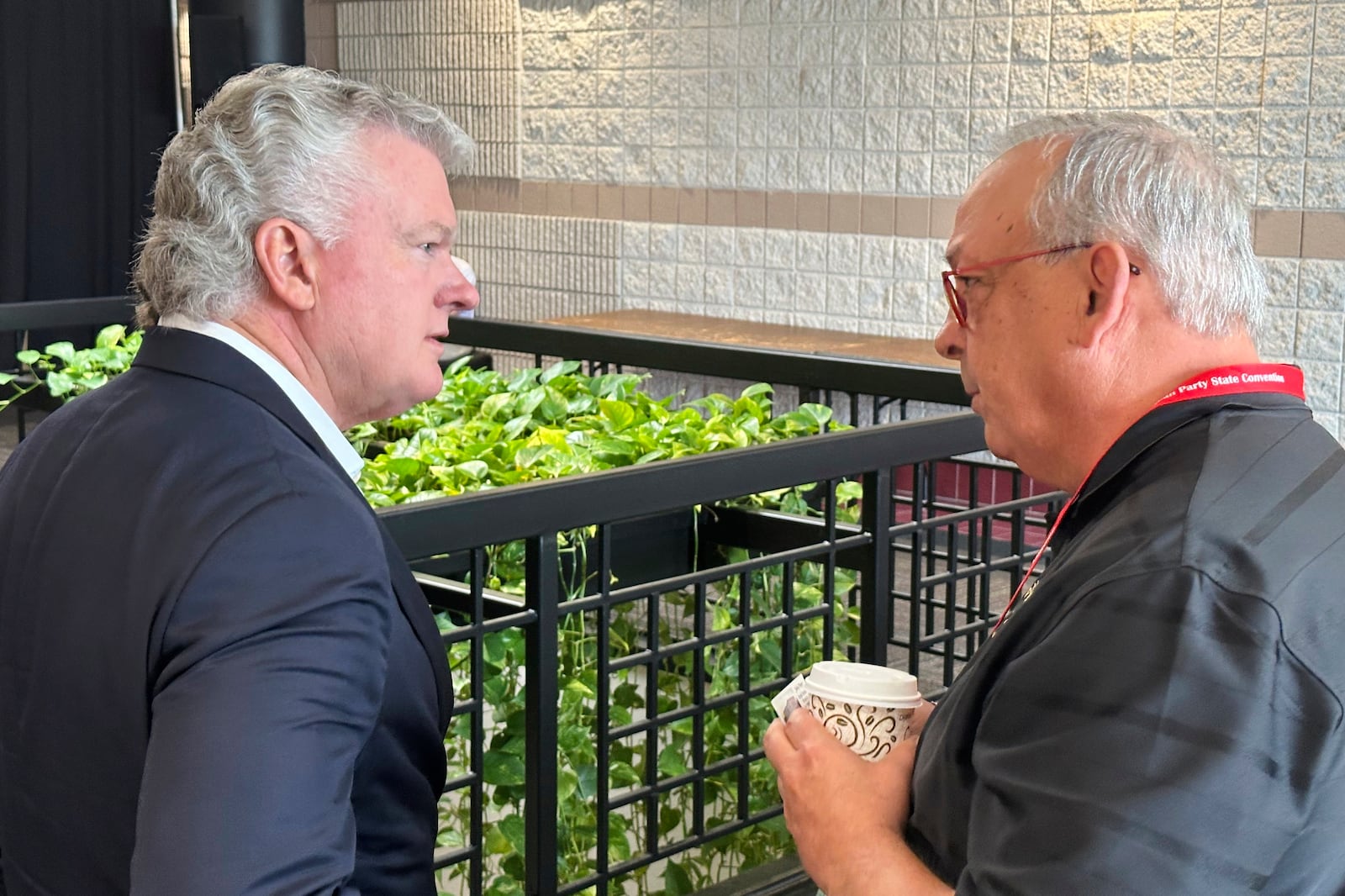 U.S. Rep. Mike Collins, left, R-Ga., speaks to an attendee at the Georgia Republican Convention in Dalton, Ga., Saturday, June 7, 2025. (AP Photo/Jeff Amy)
