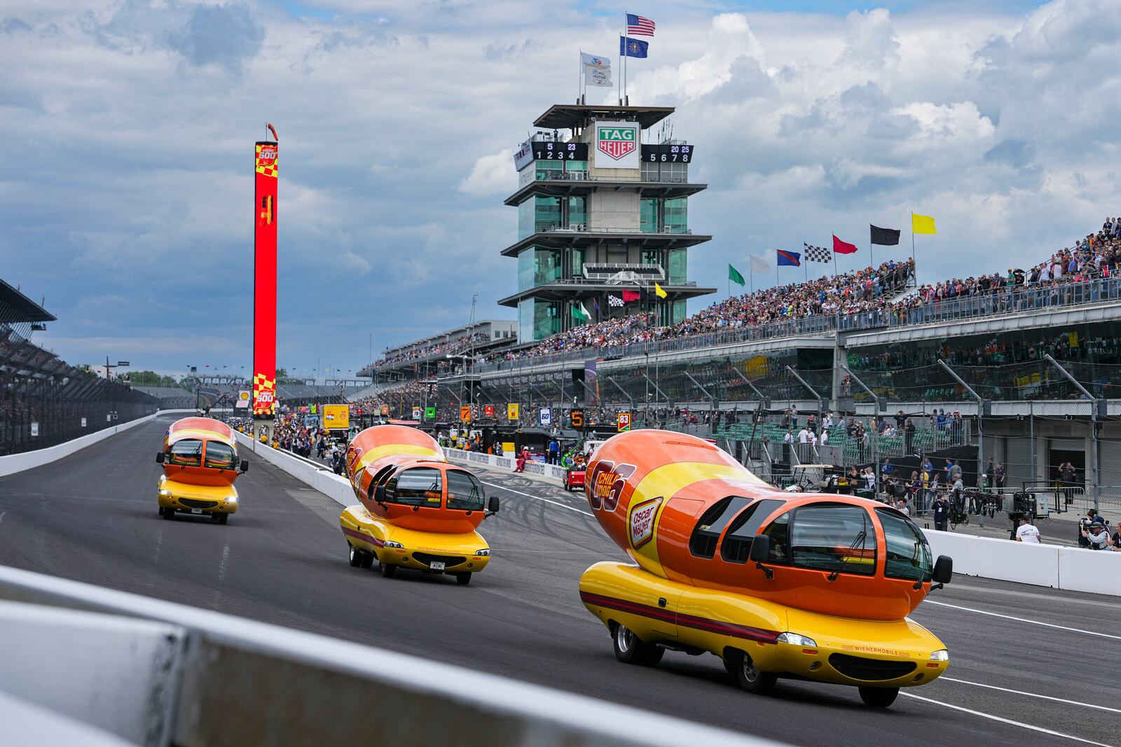 The Oscar Mayer Wienermobiles head into the first turn as they compete in the Wienie 500 following the practice session for the Indianapolis 500 auto race at Indianapolis Motor Speedway in Indianapolis, Friday, May 23, 2025. (AP Photo/Michael Conroy)