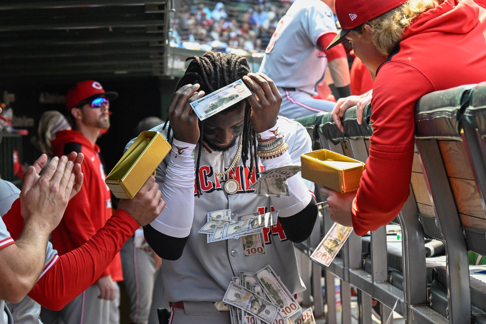 Cincinnati Reds' Elly De La Cruz is showered with fake money in the dugout after he hit a two-run home run during the sixth inning of a baseball game against the Chicago Cubs, Sunday, June 1, 2025, in Chicago. (AP Photo/Matt Marton)