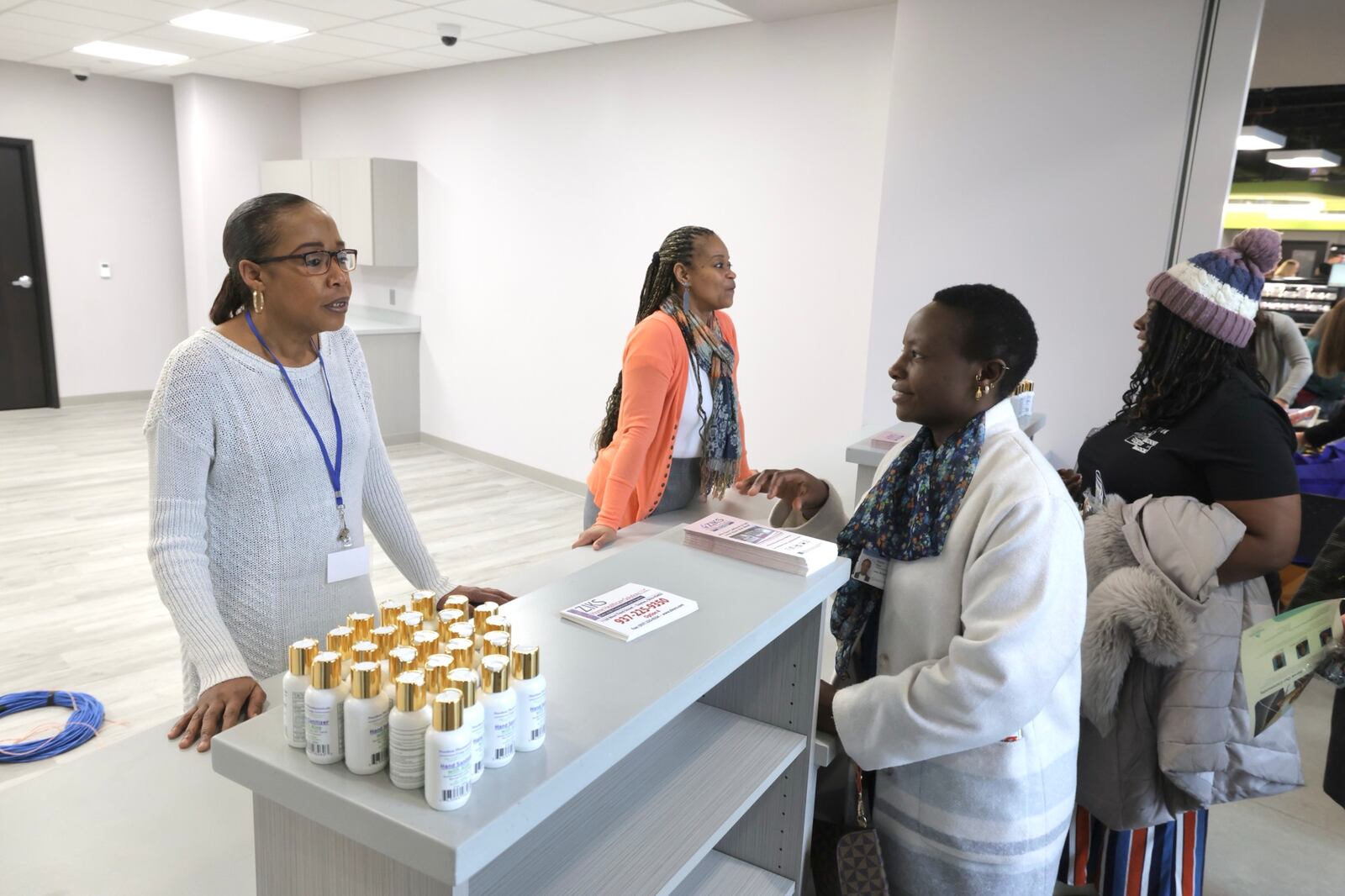 Customers talk to Zinks Pharmacy employees about the new pharmacy opening soon in Homefull’s Healthy Living in West Dayton project Thursday, Feb. 6, 2025. BILL LACKEY/STAFF